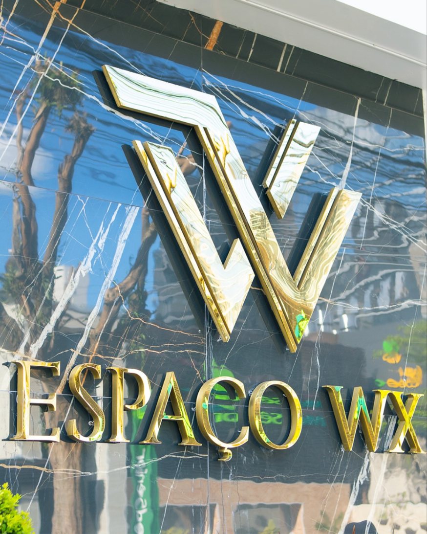 Fachada do Espaço WX em mármore com o monograma dourado